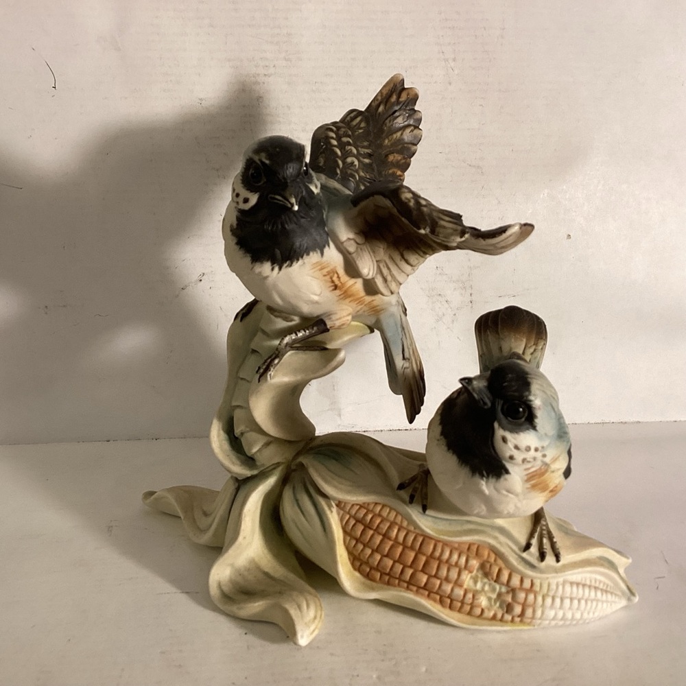 Porcelain bisque birds perched on corn